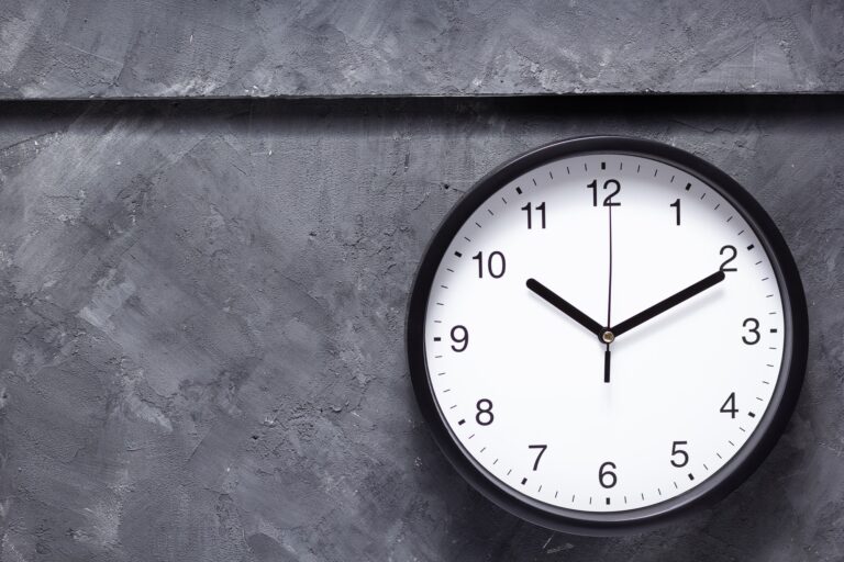 wall clock at grey concrete background
