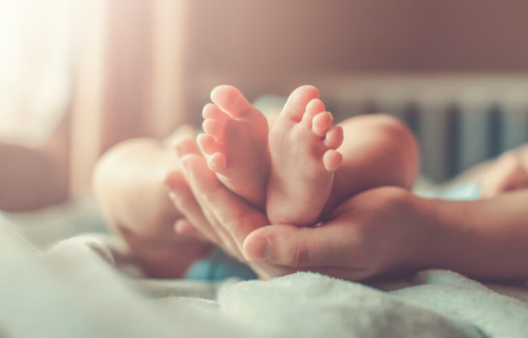 Feet of new born baby in hands of parents
